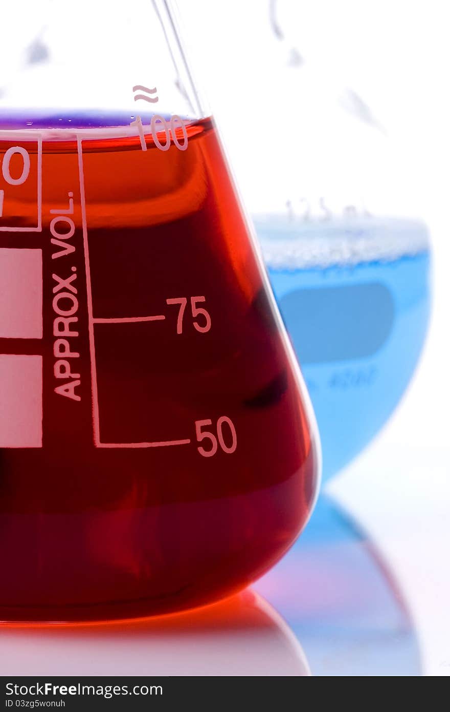 One blue and one red laboratory flask used in scientific research. One blue and one red laboratory flask used in scientific research