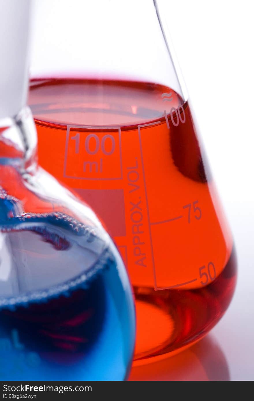 One blue and one red laboratory flask used in scientific research. One blue and one red laboratory flask used in scientific research