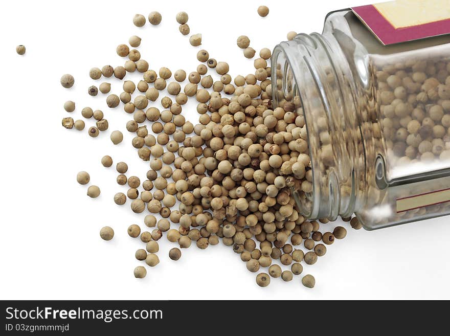 A jar with white peppercorns isolated over a white background