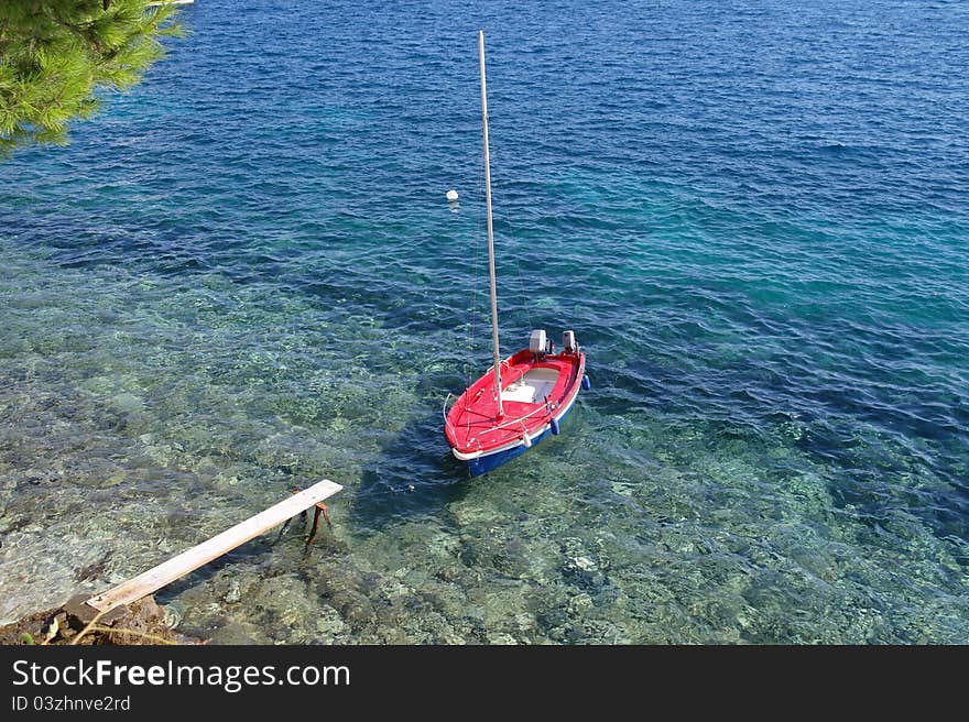 A small isolated boat sitting at the waters edge. A small isolated boat sitting at the waters edge