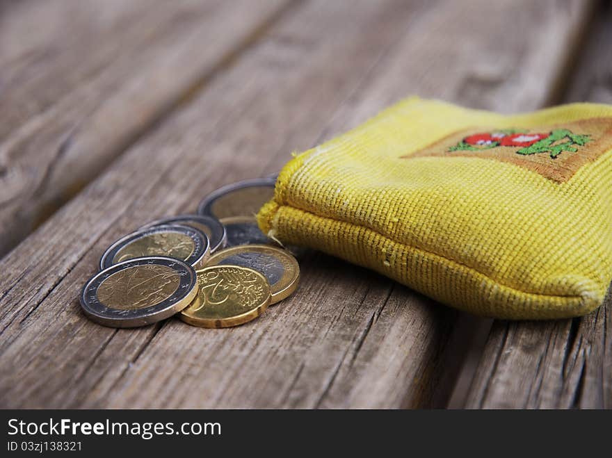 Peruvian pocket wallet with some euro coins on a public bench