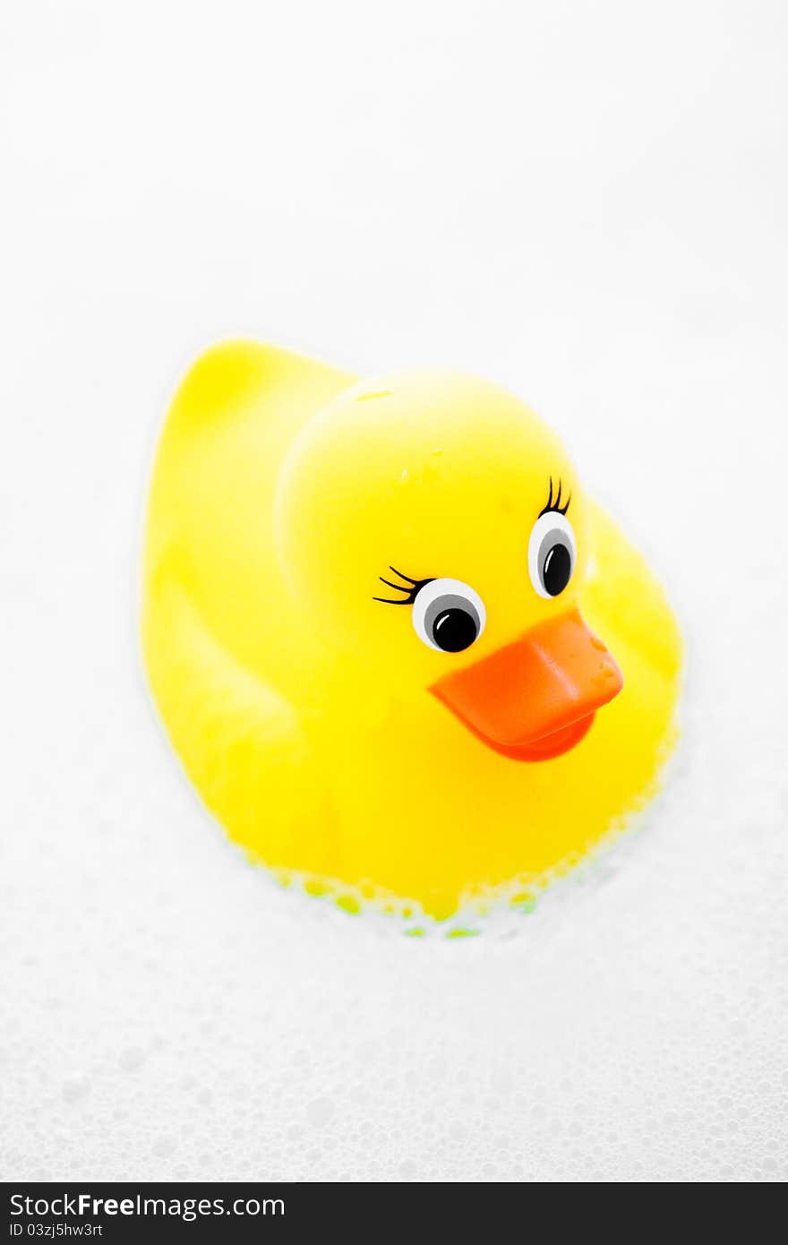 A child's play toy, a rubber ducky in a bubble bath.