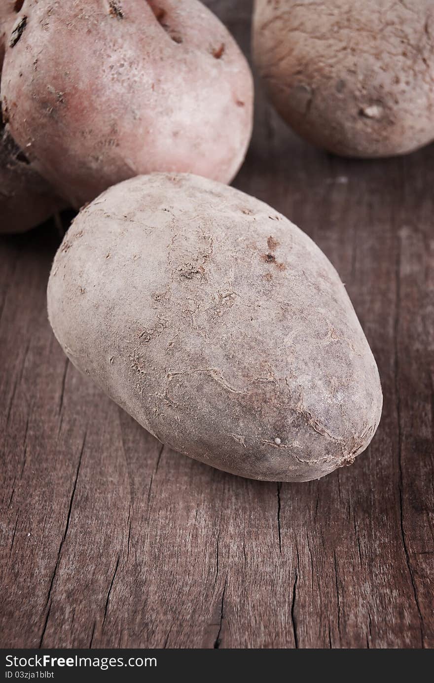 Old potatoes on a wooden plank