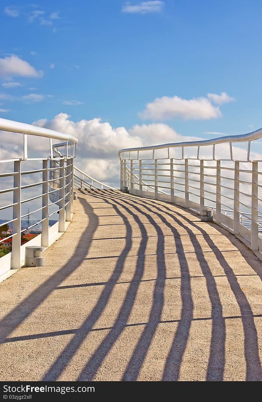 White pedestrian bridge over a highway in Majorca (Spain) with a blue sky background. White pedestrian bridge over a highway in Majorca (Spain) with a blue sky background