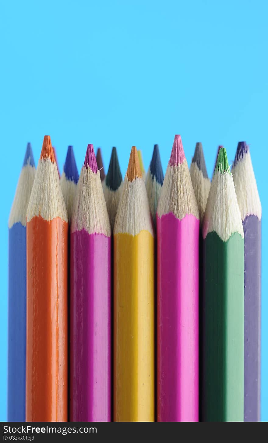 A set of colored pencils on a blue background. A set of colored pencils on a blue background