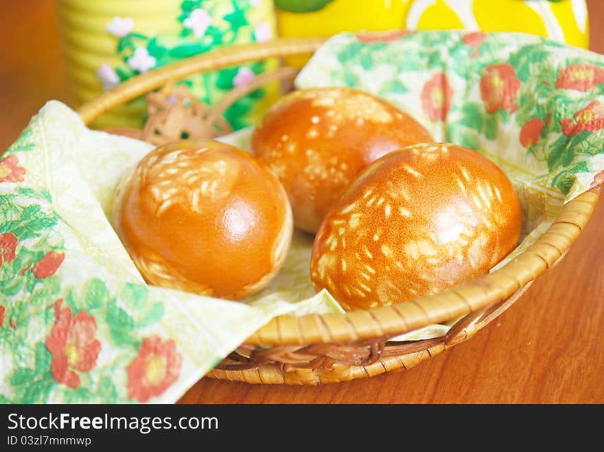 Three painted easter eggs in wood bascet