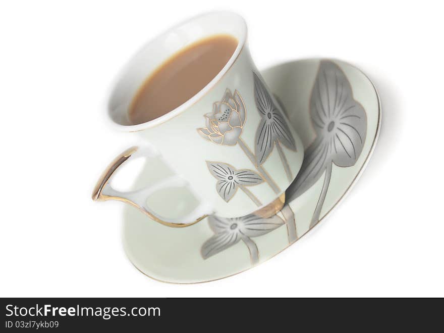 Cup of coffee with milk or cream and saucer