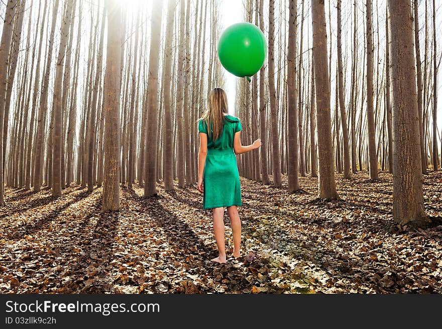 Beautiful blonde girl standing in the forest