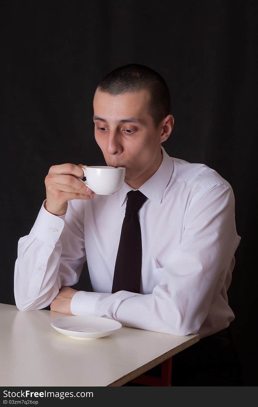 Surprised businessman drinking coffee