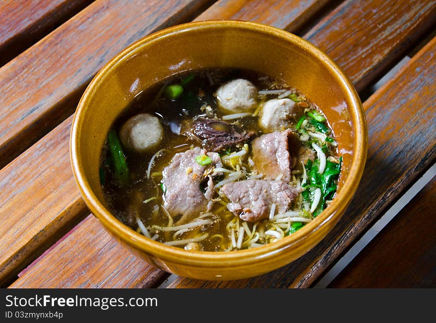 Asian soup with noodles and meat ball.