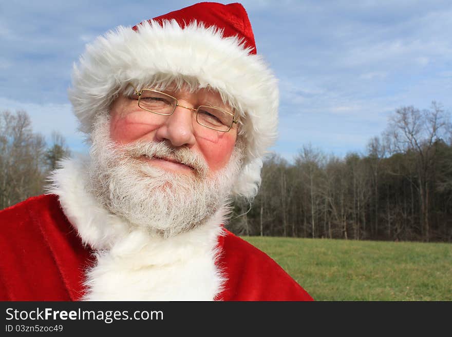 Santa smiling as he poses in an open field. Santa smiling as he poses in an open field.