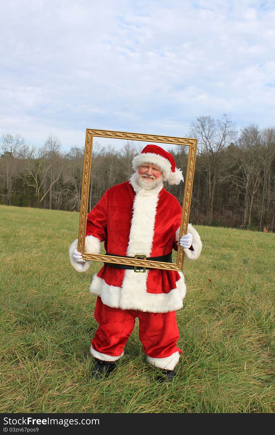 Santa in an open field holding a frame. Santa in an open field holding a frame.