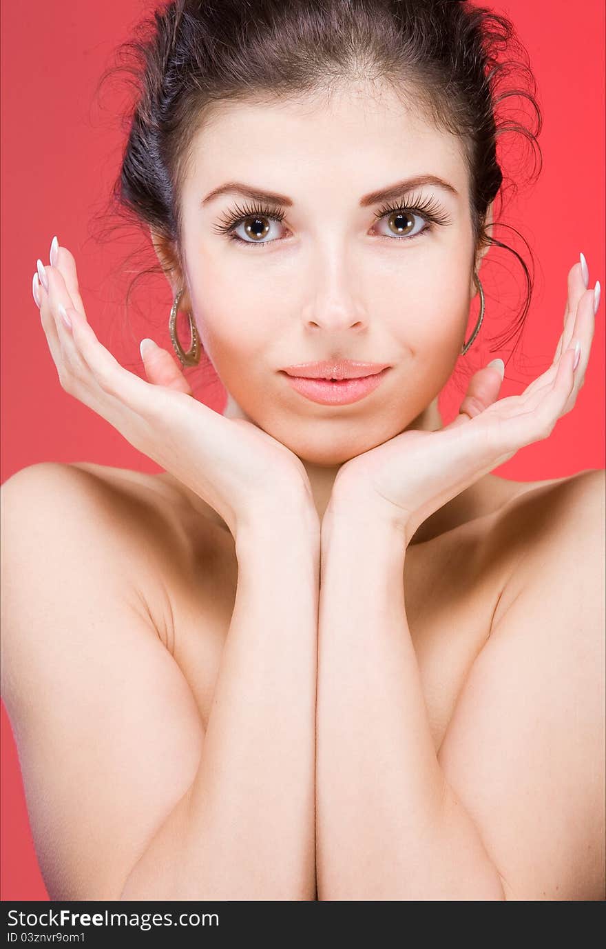 Portrait of the beautiful young brunette on a red background. Portrait of the beautiful young brunette on a red background