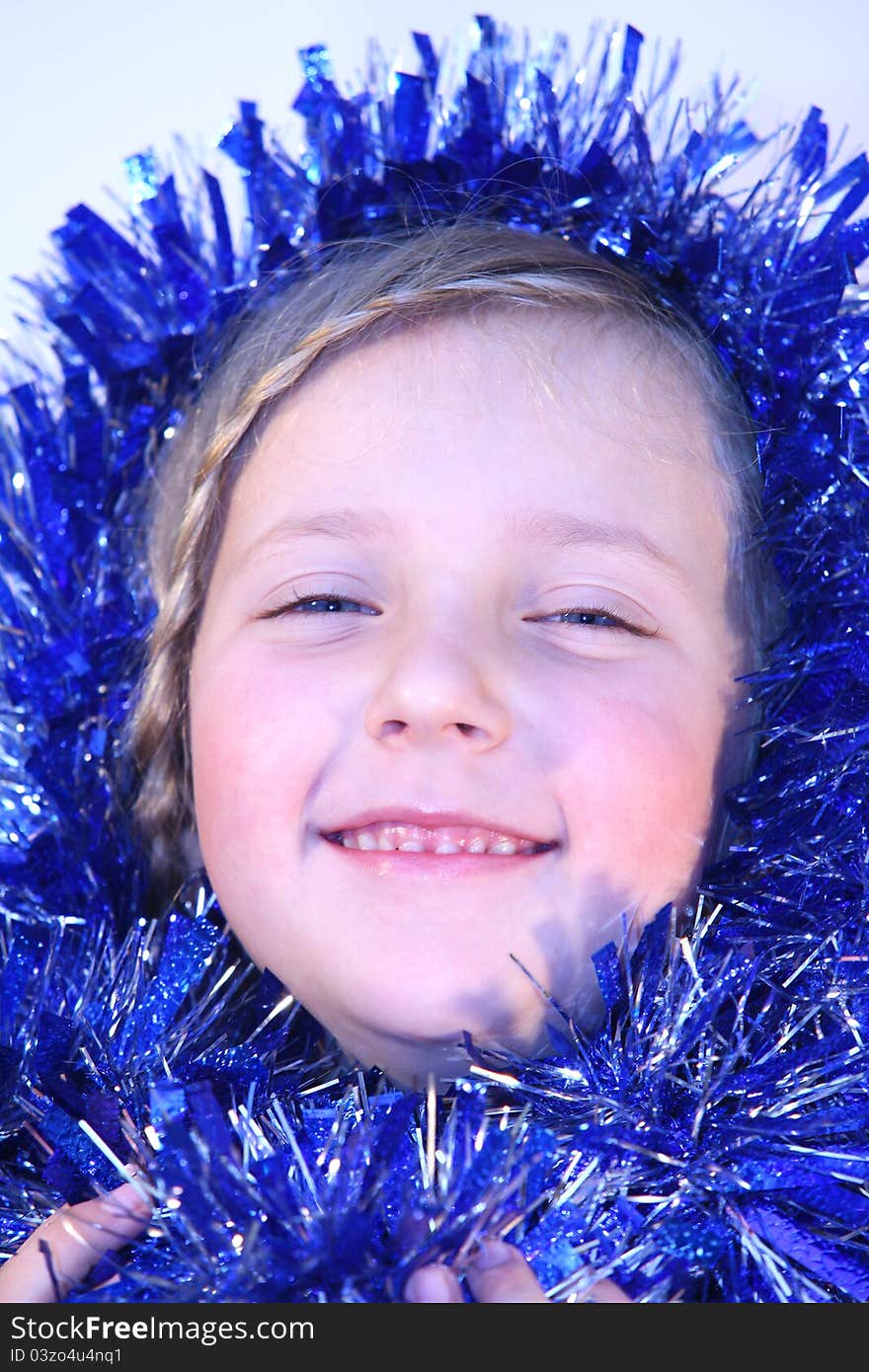 Cute girl in Christmas decorations smiles