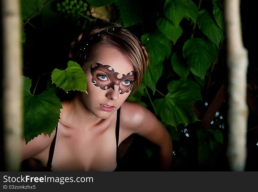 Fancy dress party - young girl in carnival mask among trunks of trees. Series of photos outdoor. Fancy dress party - young girl in carnival mask among trunks of trees. Series of photos outdoor