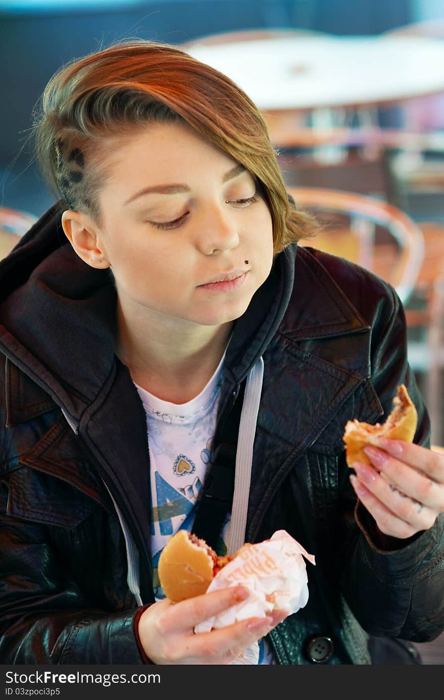 Portrait Of Girl With Eats Burger On The Terrace