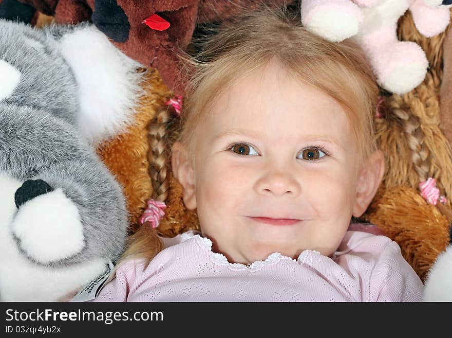 Portrait of a young girl with pigtails on the background of toys. Portrait of a young girl with pigtails on the background of toys