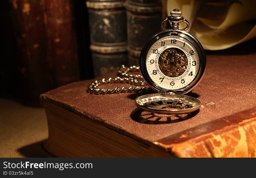 Still life with stylish pocket watch on ancient book. Still life with stylish pocket watch on ancient book