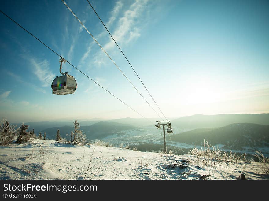 The mountain-skiing lift, blue sky and mountains. The mountain-skiing lift, blue sky and mountains