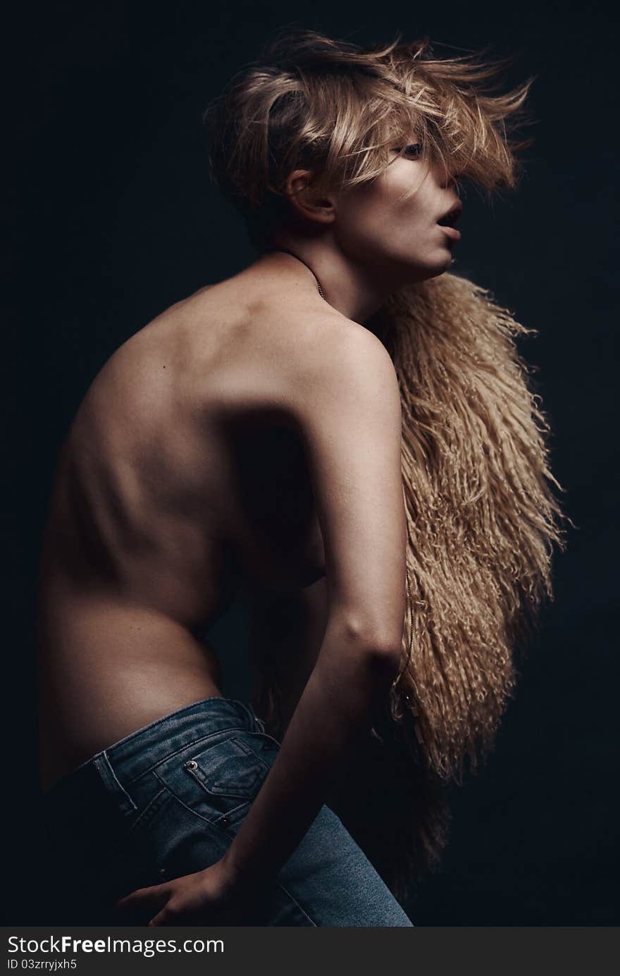 Dark Picture Of Sexy Woman In Lama Fur And Jeans