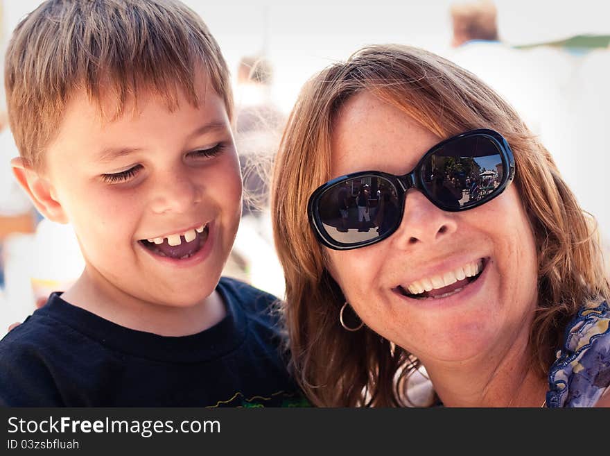 An older mother or grandmother with an 8 year old boy. Boy and women are laughing hysterically with a huge smile. Image taken outdoors. An older mother or grandmother with an 8 year old boy. Boy and women are laughing hysterically with a huge smile. Image taken outdoors.