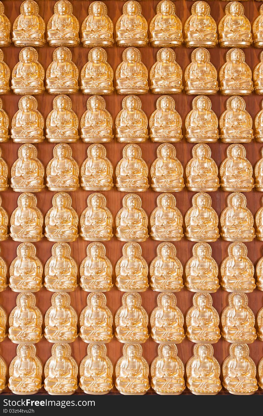 Many small Buddha statue on the wall at chinese temple, Thailand