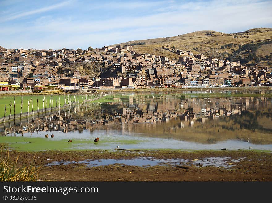 The Reflection of the city of Puno in the Titicaca lake, Peru. The Reflection of the city of Puno in the Titicaca lake, Peru