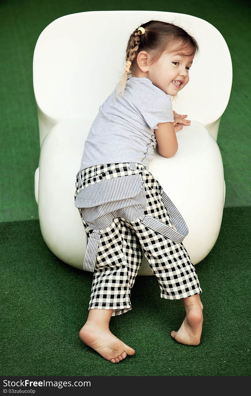 Girl Standing Beside A White Chair