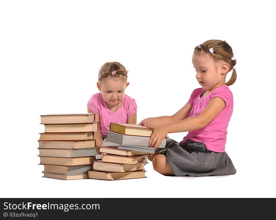 Pretty twins girls with pile of books isolated