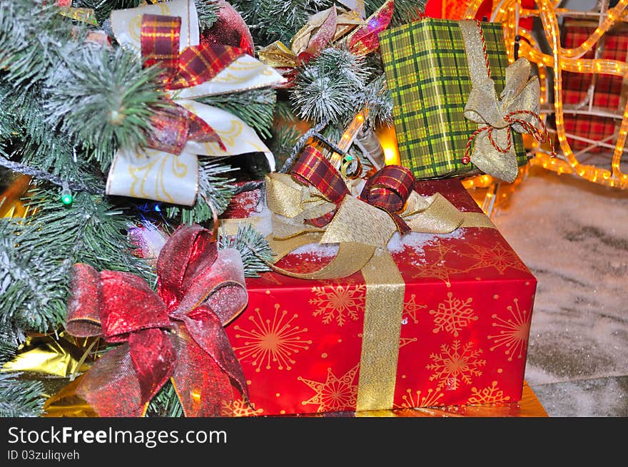 Colorful boxes with Christmas gifts under a decorated fir tree. Colorful boxes with Christmas gifts under a decorated fir tree