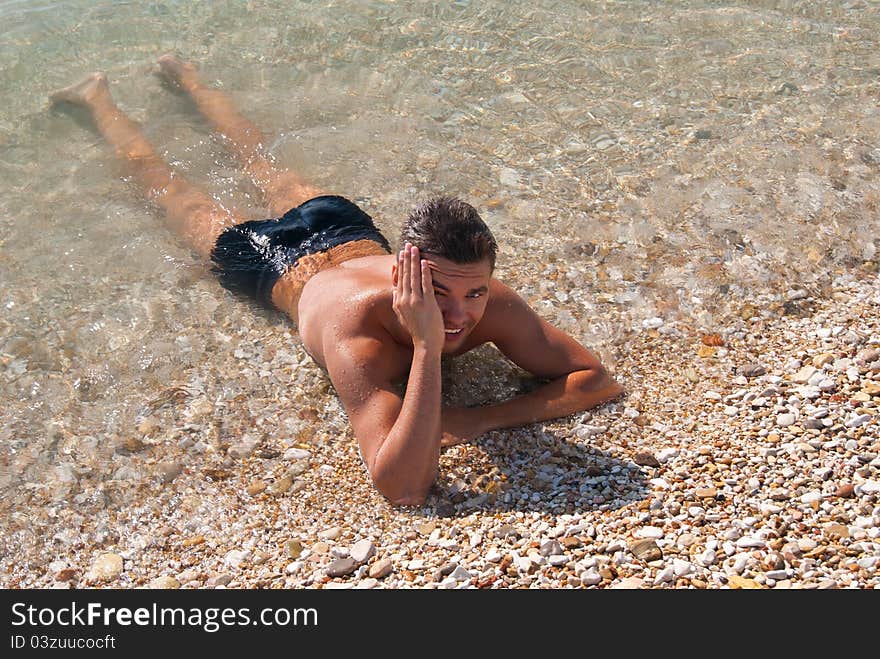 Beautiful tanned young fellow in sea water