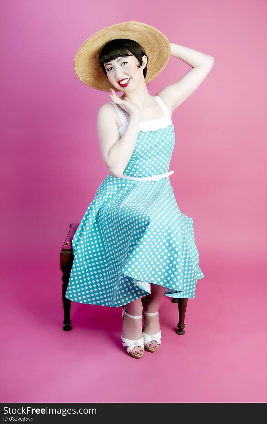 Cute pinup model wearing straw hat and polka dot dress. Cute pinup model wearing straw hat and polka dot dress