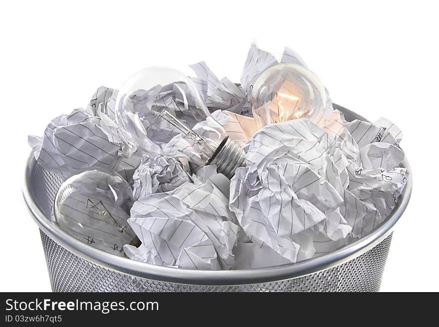 Illuminated bulb in waste bin with screwed up paper on white background. Illuminated bulb in waste bin with screwed up paper on white background