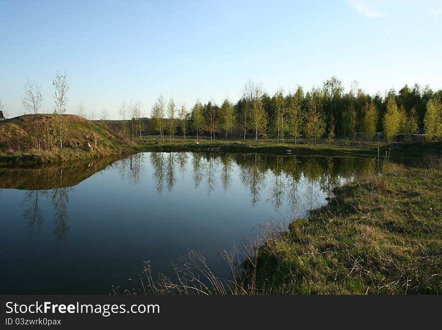 Idyllic rural Pond with sky and trees mirrored in it. Idyllic rural Pond with sky and trees mirrored in it.