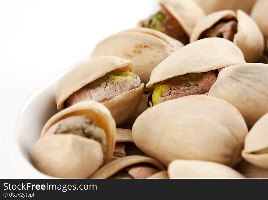 Close-up roasted and salted pistachios on white plate