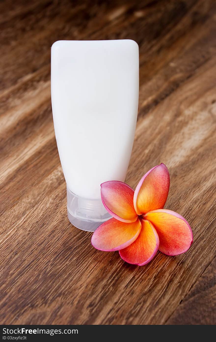 Tropical Frangipani and Toiletries on wooden table for spa and wellness concept. Tropical Frangipani and Toiletries on wooden table for spa and wellness concept