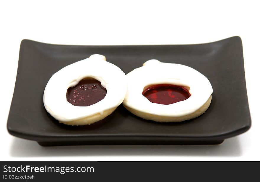 White cookies with melted sugar middles on a black plate. White cookies with melted sugar middles on a black plate