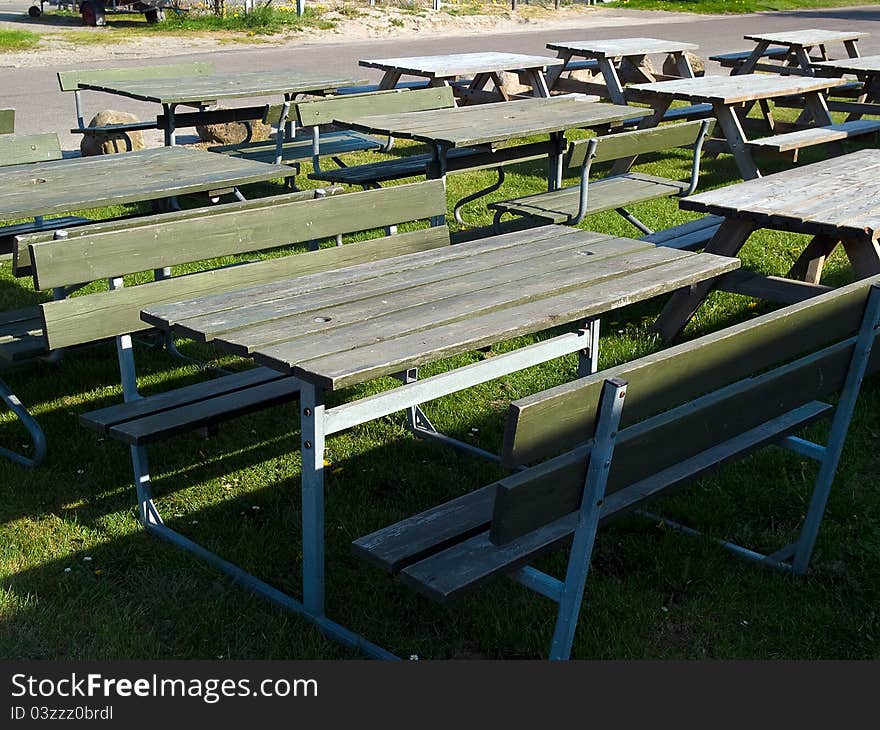 Wooden picnic tables arranged outdoors in nature