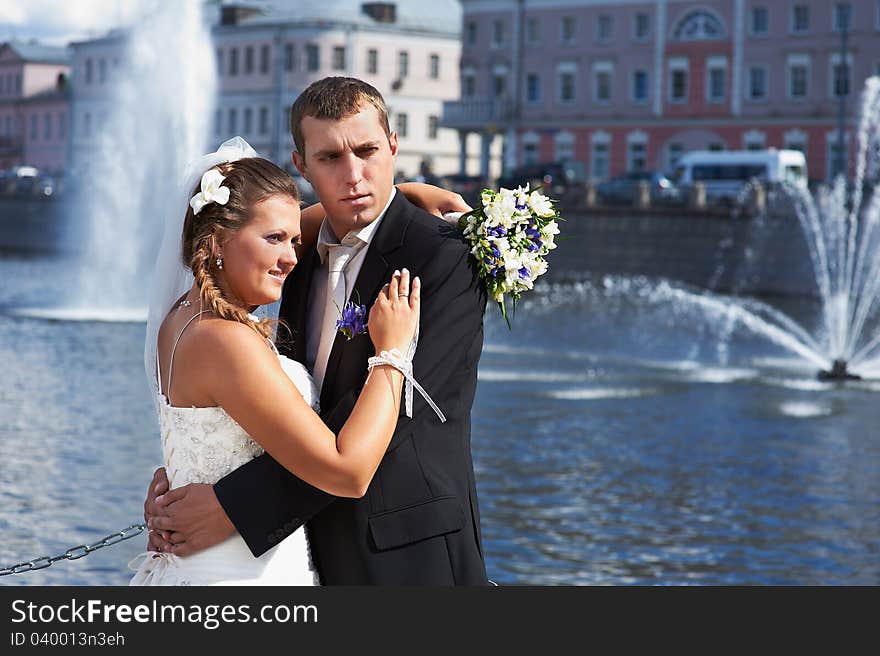 Bride and groom and fountains on river