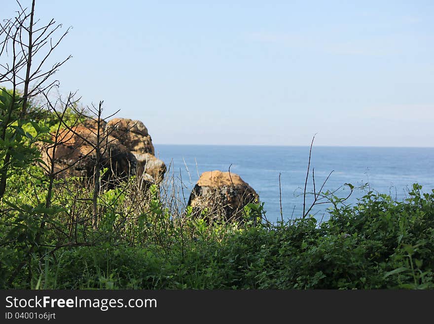 Natural view of arabean sea through rocks and green bushes, asia. Natural view of arabean sea through rocks and green bushes, asia