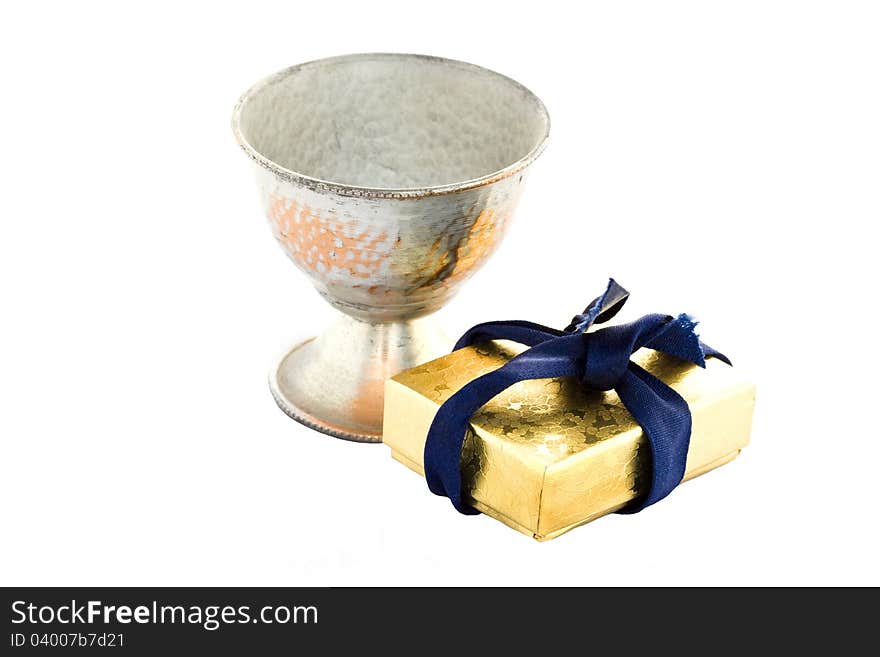 Golden gift box and old metal sneezer over white background.