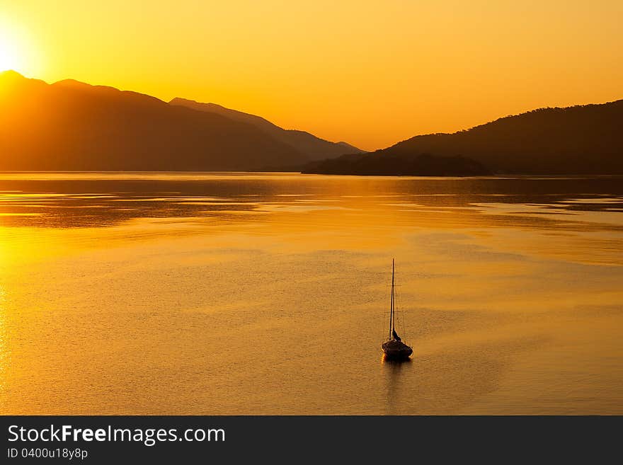 Lonely boat in the sea on sunrise in a calm