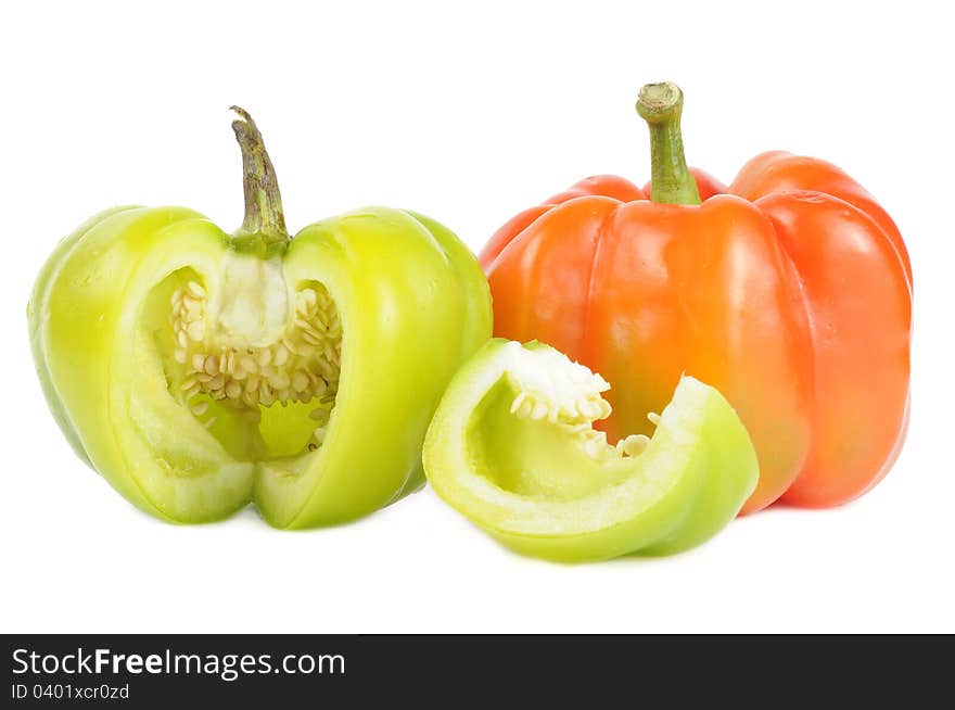 A red and a cut green bell pepper on a white background. A red and a cut green bell pepper on a white background