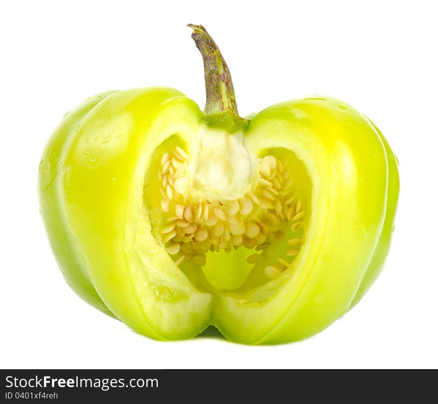 A cut green bell pepper with seeds on a white background