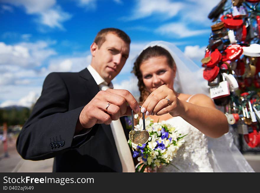 Happy bride and groom with padlock