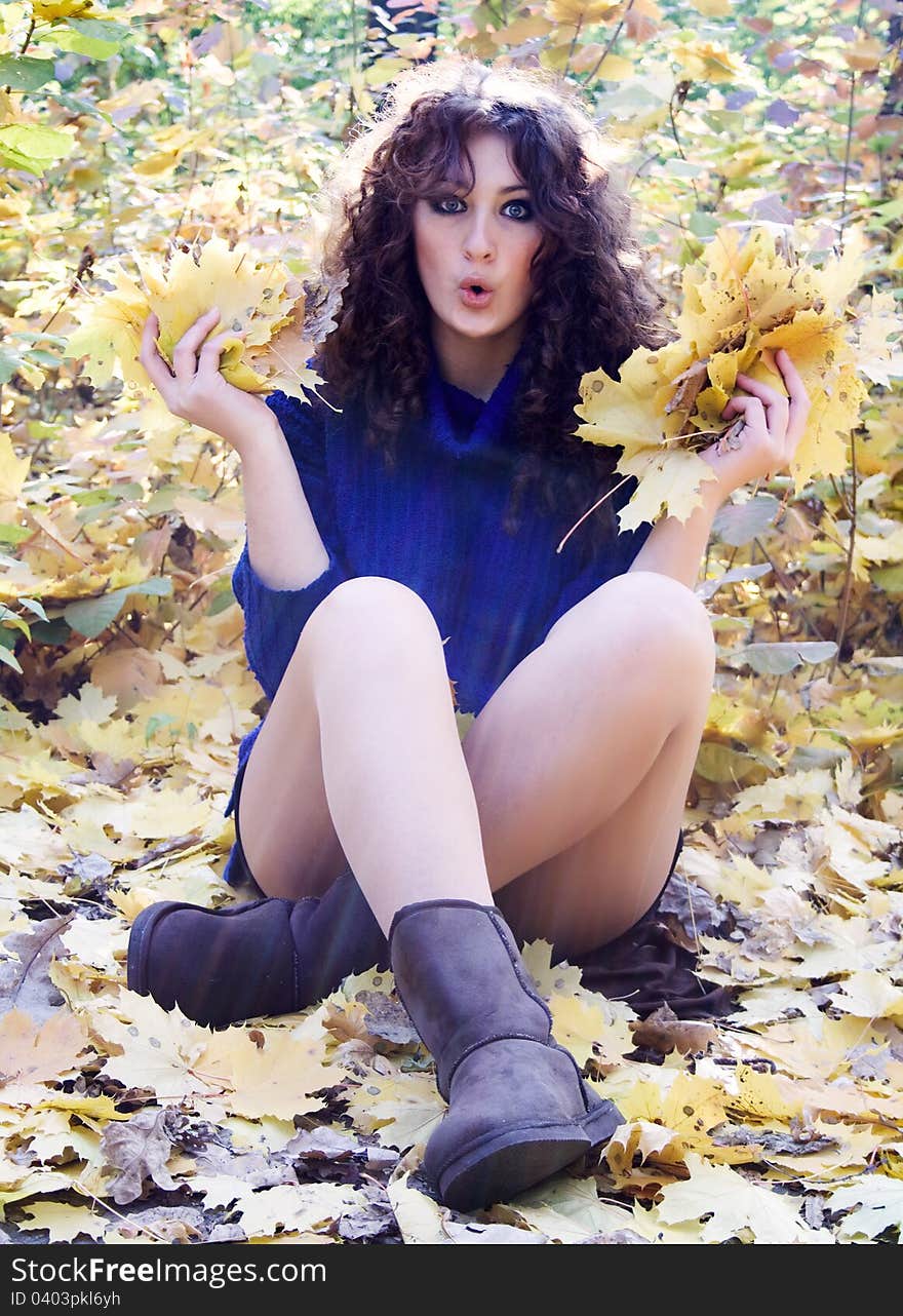 Young happy woman against the backdrop of autumn foliage yellow. Young happy woman against the backdrop of autumn foliage yellow.