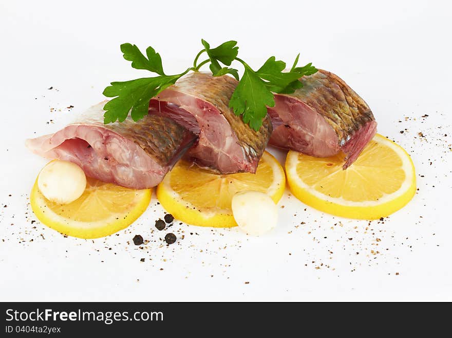 Cutting of crude fish on a lemon and black pepper on the white