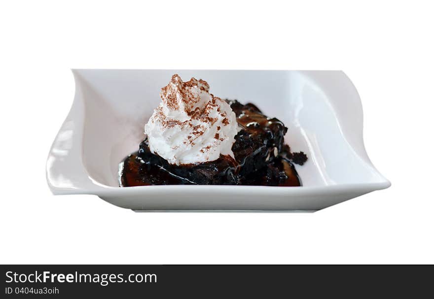 Brownie cake served with chocolate sauce and whipped cream. Brownie cake served with chocolate sauce and whipped cream