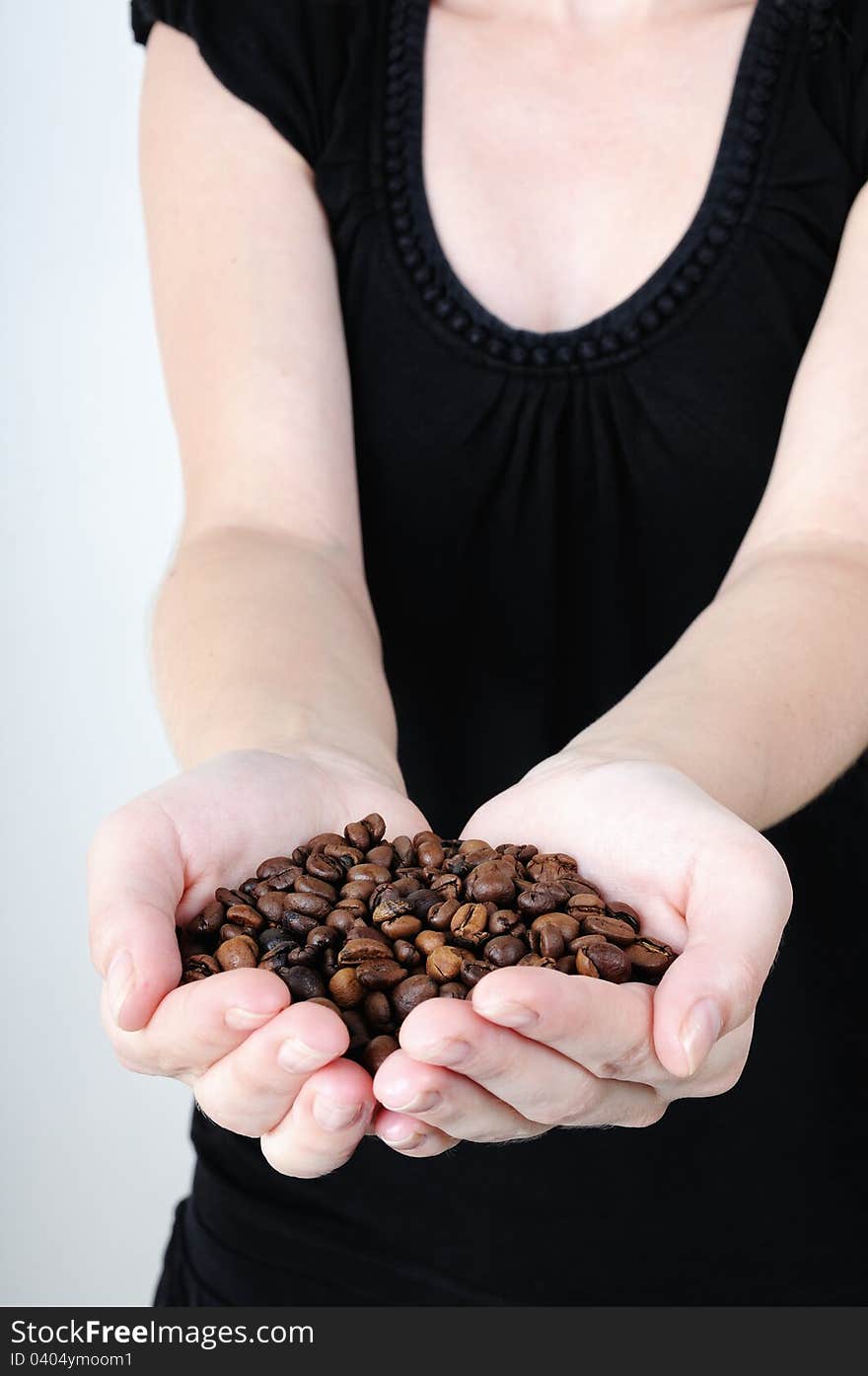 Woman holding hands in coffee beans