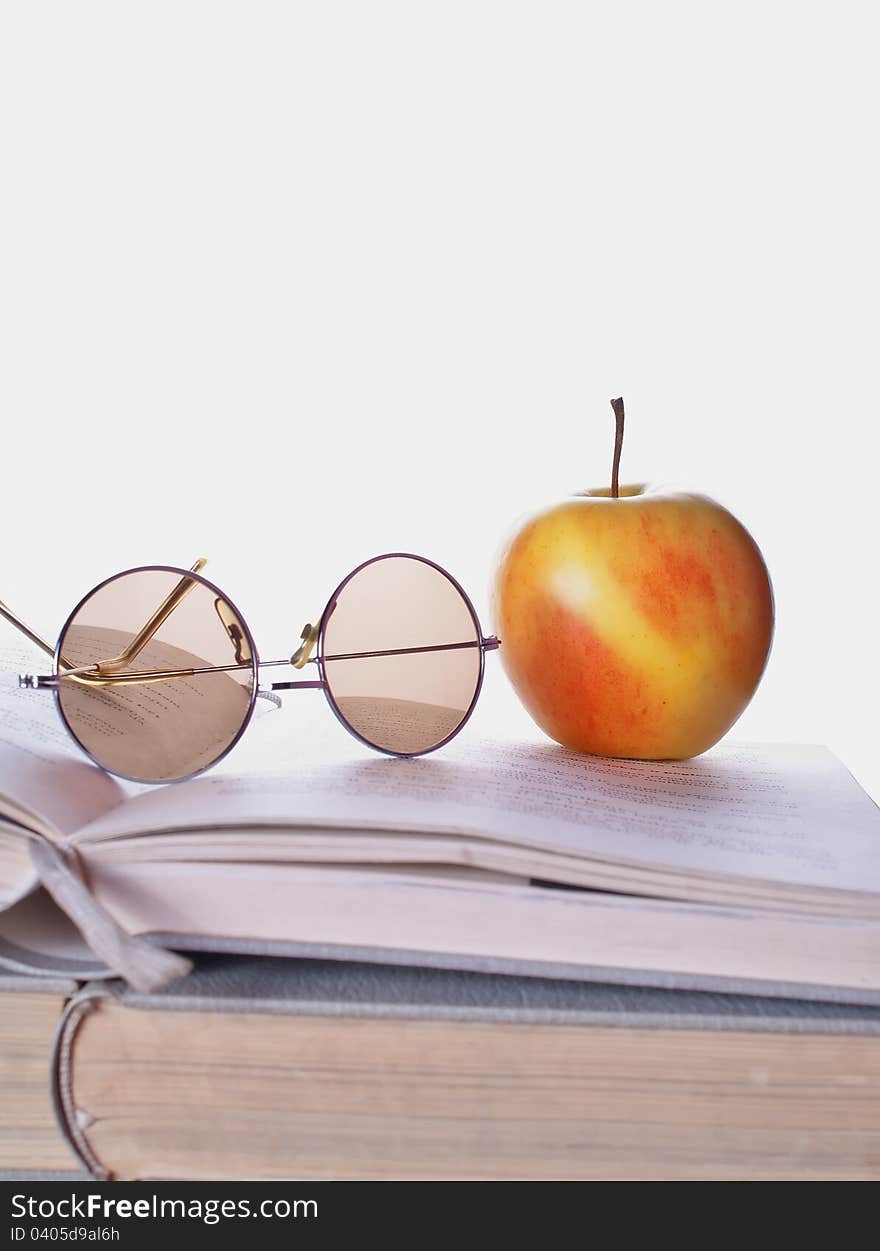 Composition with book and apple on the wooden table